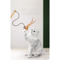おもちゃのティーザースティックを演奏するフェザーインタラクティブな猫